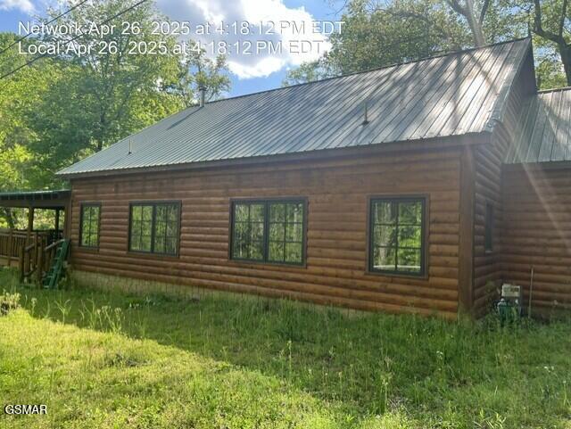 414 Swaying Pines Dr, Sevierville, TN 37876 - view of side of home featuring a metal roof, a lawn, and log veneer siding