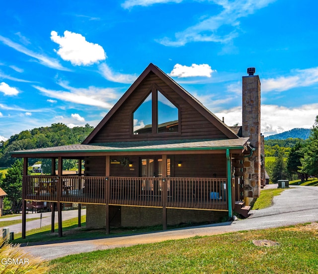 view of front of house featuring a shingled roof and a chimney