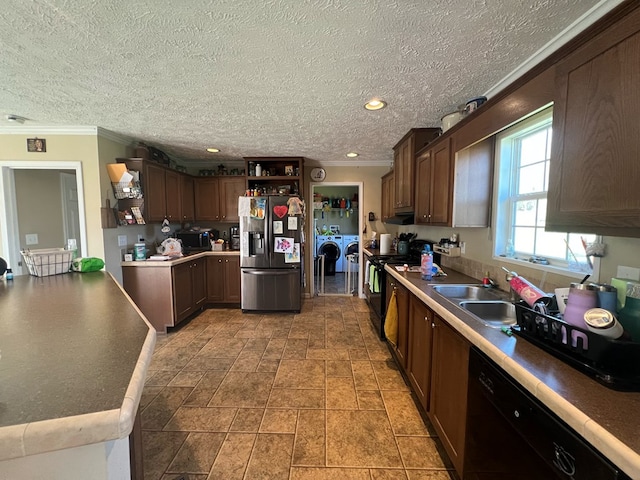 kitchen featuring dark brown cabinetry, sink, independent washer and dryer, black appliances, and ornamental molding