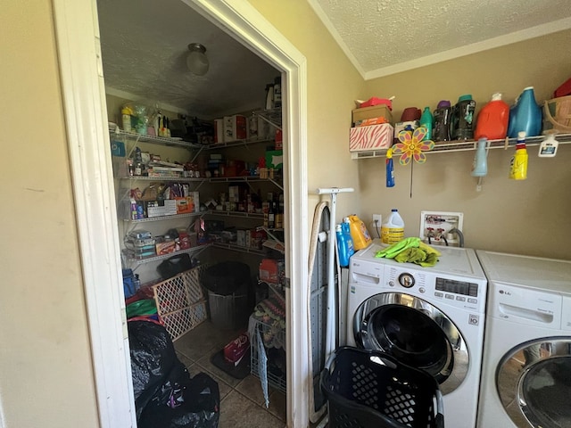 laundry area featuring washer and clothes dryer, light tile patterned floors, and a textured ceiling