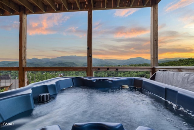 exterior space with a mountain view and a hot tub