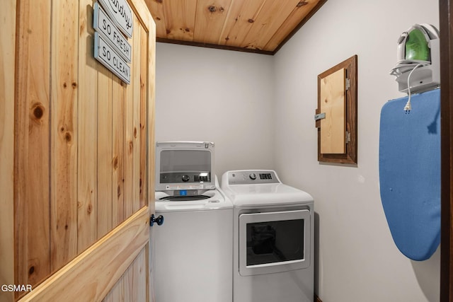 clothes washing area featuring washer and dryer, wooden ceiling, and laundry area