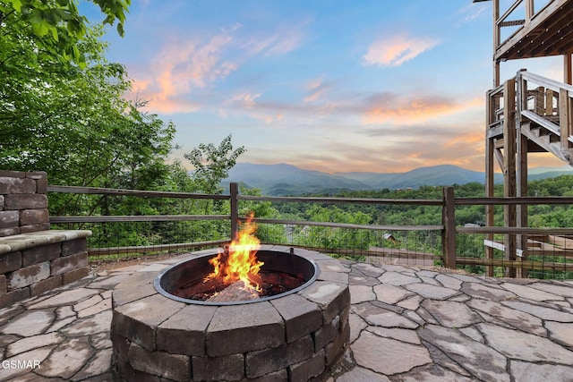 view of patio / terrace with stairway, a mountain view, and an outdoor fire pit