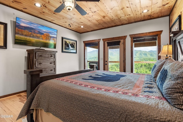 bedroom featuring access to exterior, multiple windows, wood ceiling, and wood finished floors