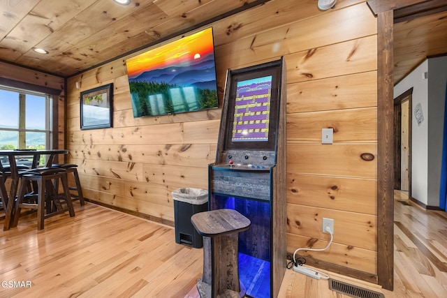 interior space with wooden walls, wood finished floors, visible vents, baseboards, and wooden ceiling