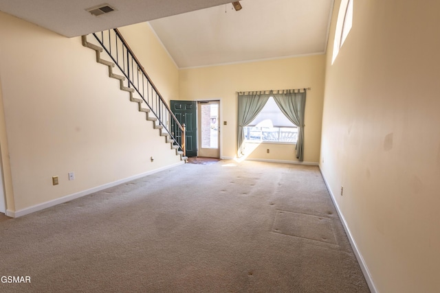 unfurnished living room featuring a towering ceiling and carpet