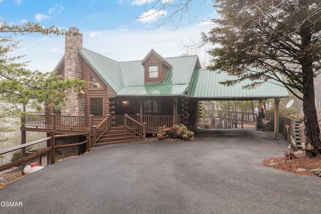 log home featuring a deck, a carport, and covered porch