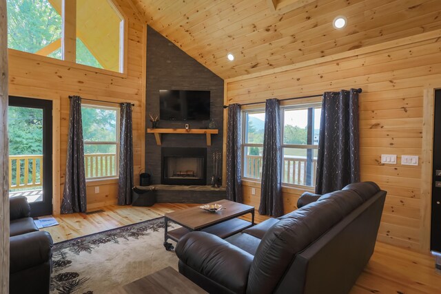 living room with a stone fireplace, sink, high vaulted ceiling, and wooden ceiling