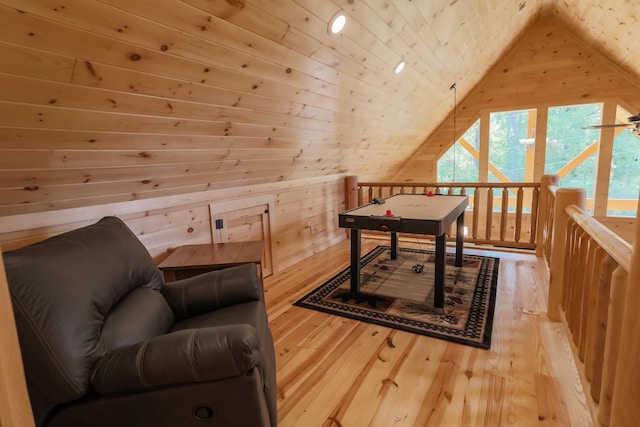 interior space with wood walls, lofted ceiling, hardwood / wood-style flooring, ceiling fan, and wood ceiling