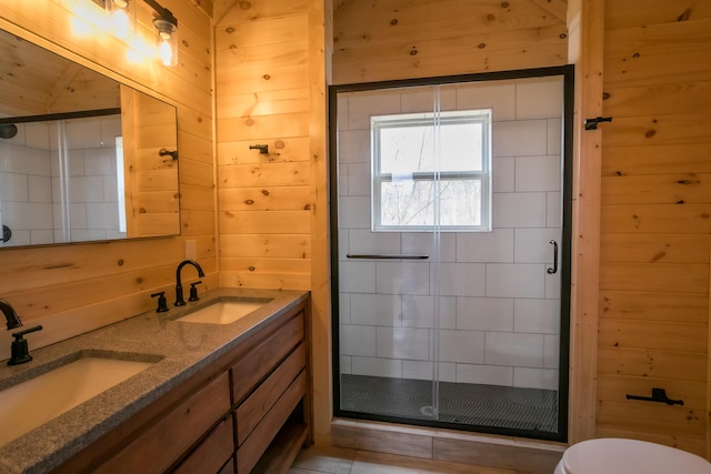 full bathroom featuring a sink, wood walls, and a shower stall