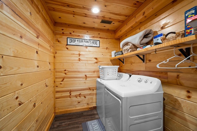 laundry area with laundry area, wood ceiling, independent washer and dryer, and wood walls