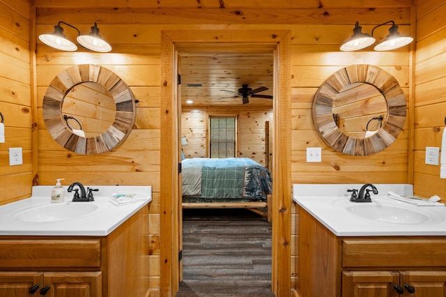 full bath featuring wooden walls, connected bathroom, and a sink