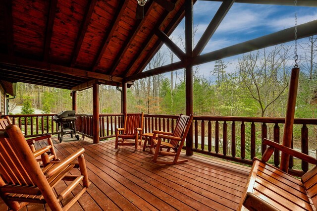 wooden deck featuring a forest view and grilling area