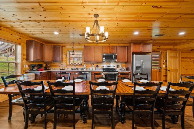 kitchen with wooden ceiling, plenty of natural light, brown cabinetry, and appliances with stainless steel finishes