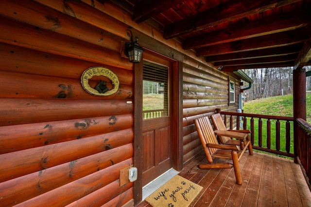 property entrance featuring faux log siding and covered porch