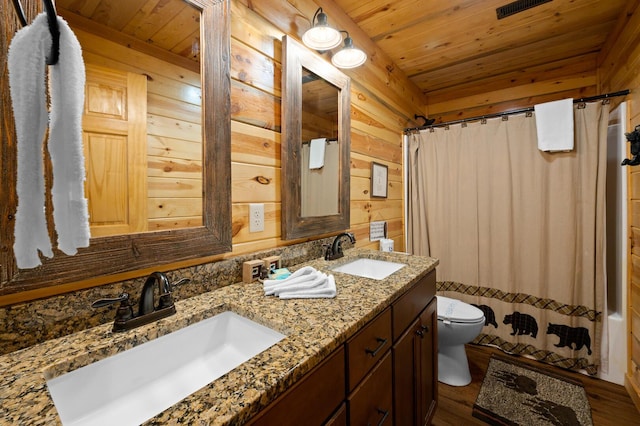 full bathroom featuring toilet, wood ceiling, and a sink