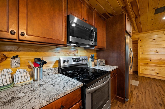 kitchen featuring wood finished floors, light stone countertops, visible vents, stainless steel appliances, and wooden ceiling