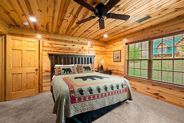 bedroom featuring carpet flooring, wood walls, wooden ceiling, and visible vents