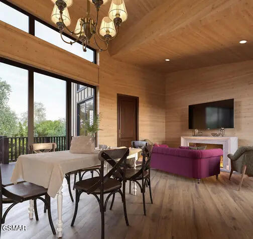 dining space featuring hardwood / wood-style floors, wood ceiling, wooden walls, and an inviting chandelier