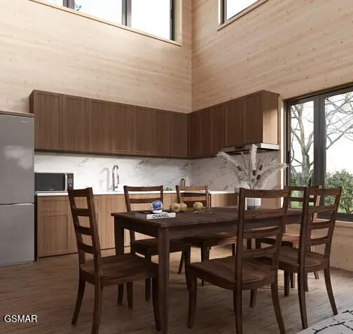 dining space with a high ceiling and hardwood / wood-style flooring