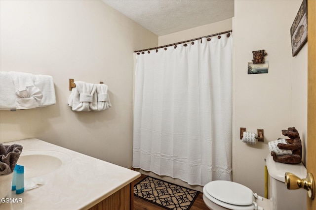 bathroom featuring vanity, curtained shower, toilet, and a textured ceiling