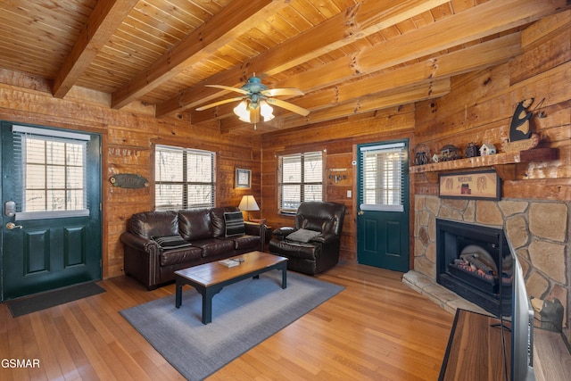 living room featuring wooden ceiling, light wood-style flooring, beamed ceiling, and wood walls