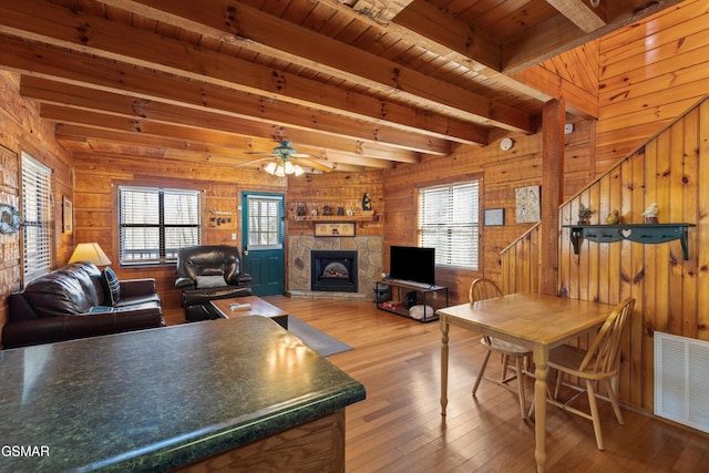 living room featuring beamed ceiling, visible vents, and a healthy amount of sunlight