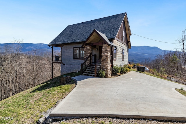 chalet / cabin with a mountain view, brick siding, and roof with shingles