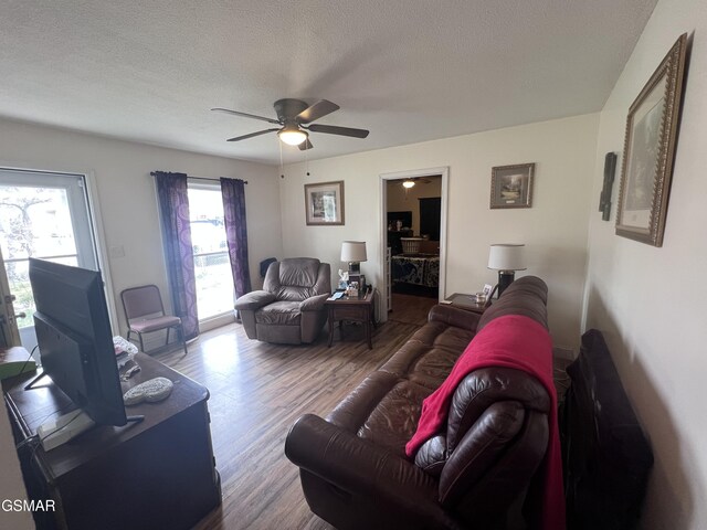 living area featuring a textured ceiling, ceiling fan, and wood finished floors