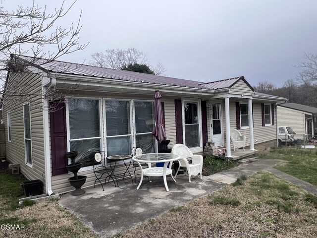 rear view of property with a patio and metal roof