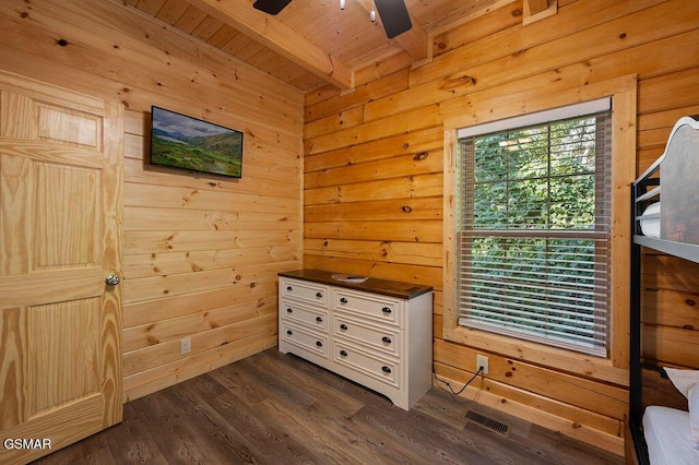 bedroom featuring wood walls, wooden ceiling, dark wood-type flooring, ceiling fan, and beamed ceiling