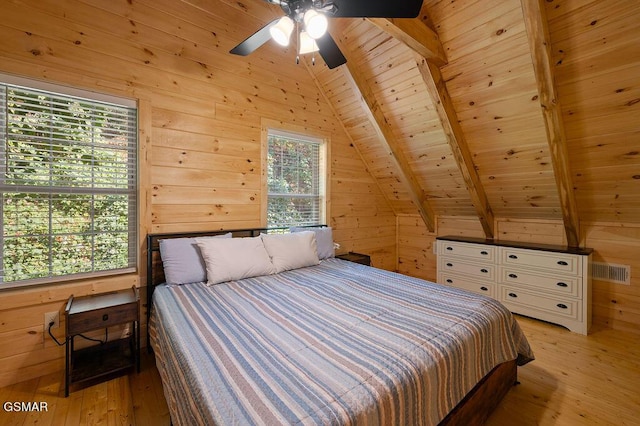 bedroom with light wood-type flooring, lofted ceiling with beams, wooden ceiling, and wood walls