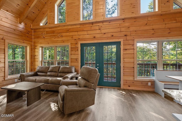 living room with beam ceiling, wooden ceiling, high vaulted ceiling, hardwood / wood-style floors, and wooden walls