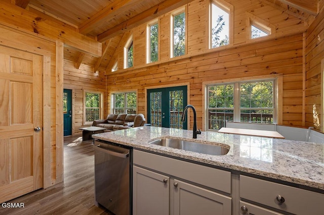 kitchen featuring dishwasher, high vaulted ceiling, sink, beamed ceiling, and light stone counters