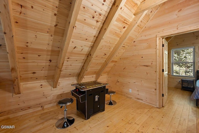 bonus room featuring vaulted ceiling with beams, light hardwood / wood-style floors, wooden ceiling, and wooden walls