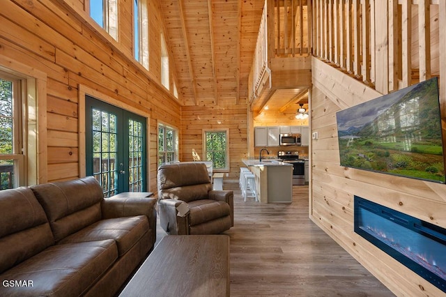 living room featuring sink, french doors, high vaulted ceiling, wood ceiling, and hardwood / wood-style flooring