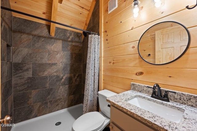 bathroom with vanity, toilet, curtained shower, and wooden walls