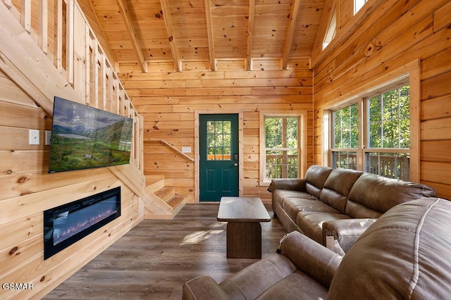 living room with beam ceiling, wooden walls, high vaulted ceiling, and wood ceiling