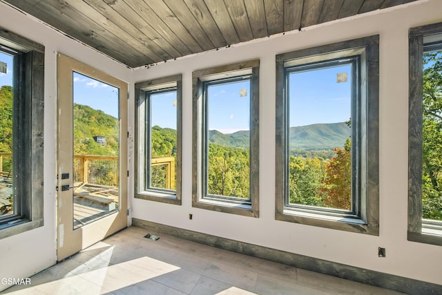 unfurnished sunroom with a mountain view and wood ceiling