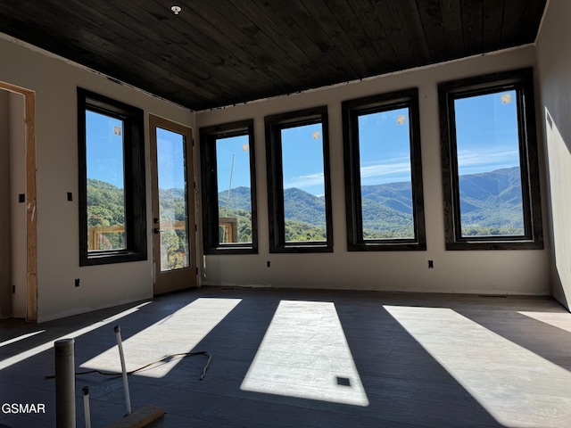 empty room featuring a mountain view and dark hardwood / wood-style flooring