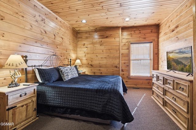 bedroom featuring wooden ceiling, wooden walls, and dark colored carpet