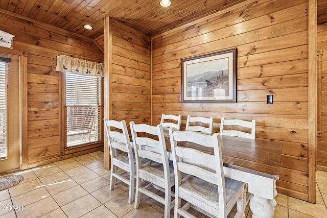 tiled dining area featuring wooden ceiling and wooden walls