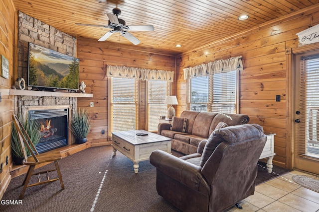 living room with ceiling fan, wood ceiling, a fireplace, and a healthy amount of sunlight