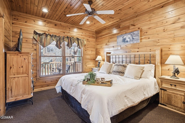 bedroom with ceiling fan, dark carpet, and wooden ceiling