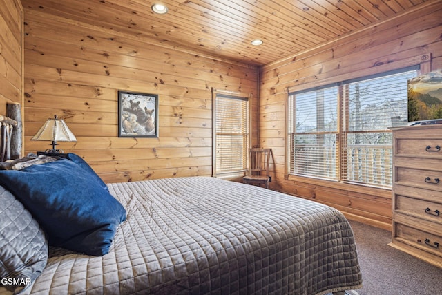 bedroom featuring wooden ceiling, carpet floors, and wooden walls