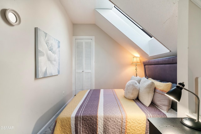 bedroom with a closet and vaulted ceiling with skylight