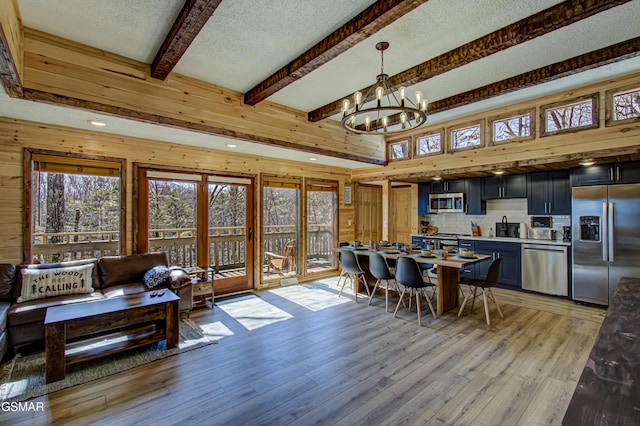 1125 Tanrac Trl, Gatlinburg, TN 37738 - dining space featuring light wood-style flooring, a textured ceiling, a chandelier, beamed ceiling, and wood walls