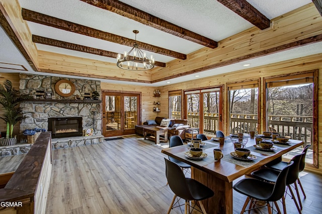 1125 Tanrac Trl, Gatlinburg, TN 37738 - dining area featuring wood walls, an inviting chandelier, wood finished floors, beamed ceiling, and a textured ceiling