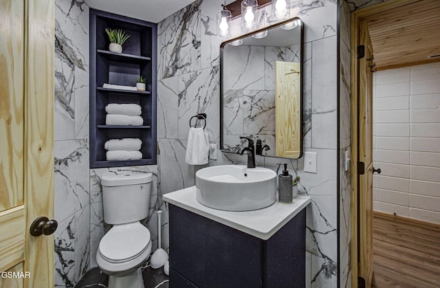 1125 Tanrac Trl, Gatlinburg, TN 37738 - bathroom featuring wood finished floors, toilet, vanity, tile walls, and built in features
