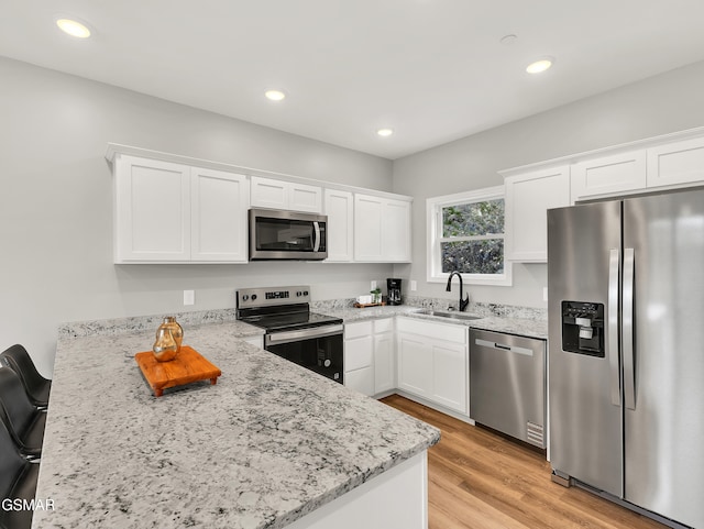 3141 Teaster Ln Unit 1, Pigeon Forge, TN 37863 - kitchen featuring stainless steel appliances, a peninsula, white cabinets, light wood-style flooring, and recessed lighting